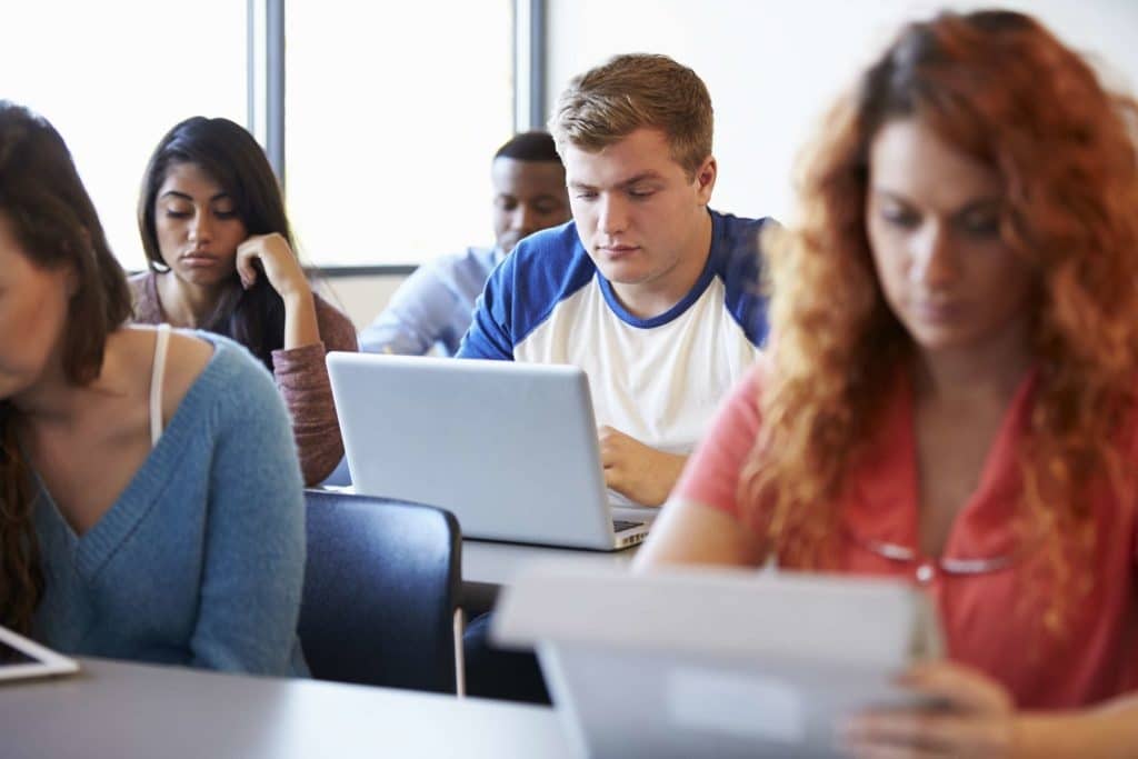 student using laptop in classroom