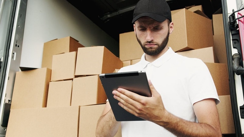 A mover next to boxes looking up methods moving businesses use to stay competitive